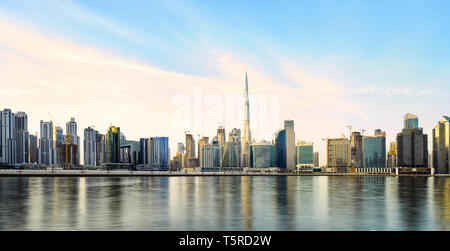 Superbe vue panoramique de la ville de Dubaï pendant le coucher du soleil avec le magnifique Burj Khalifa et beaucoup d'autres bâtiments et gratte-ciel reflété sur un s Banque D'Images