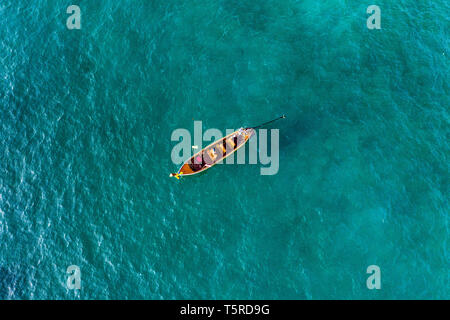 Vue de dessus, vue aérienne d'une belle longue queue bateau naviguant sur une mer turquoise. Phi Phi Islands, Maya Bay, province de Krabi, Thaïlande. Banque D'Images