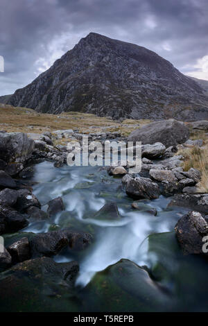 La forme triangulaire de Pen An Wen Ole s'élève au-dessus de la rivière dans la vallée de Idwal Ogwen, Snowdonia. Banque D'Images