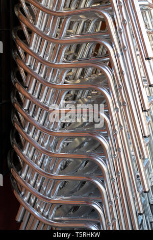 Pile de chaises en aluminium dans un restaurant.Metal chaises empilées dans la rue. Banque D'Images