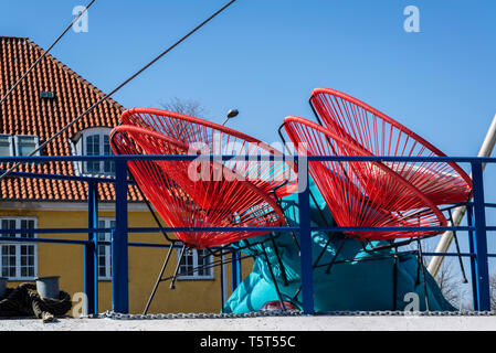 Chaises rouges sur un bateau sur l'île de Refshaleoen, un ancien site industriel dans le port de Copenhague, Danemark Banque D'Images