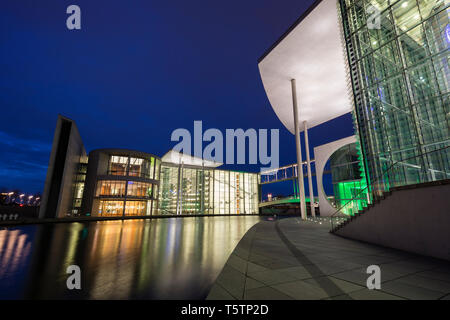 Moderne éclairé des édifices gouvernementaux Paul-Loebe-House et Marie-Elisabeth-Luders-Haus par la rivière Spree à Berlin, en Allemagne, au crépuscule. Banque D'Images