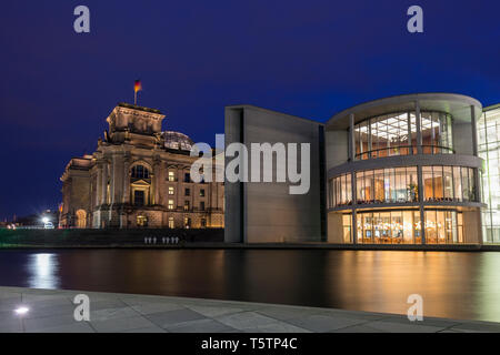 Bâtiment du Parlement Reichstag illuminée et son dôme en verre et Paul-Loebe-House par la rivière Spree à Berlin, en Allemagne, au crépuscule. Banque D'Images