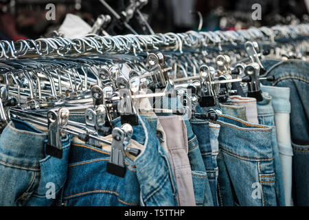 Jeans sur cintres, magasin de seconde main, pantalons - gros plan Banque D'Images