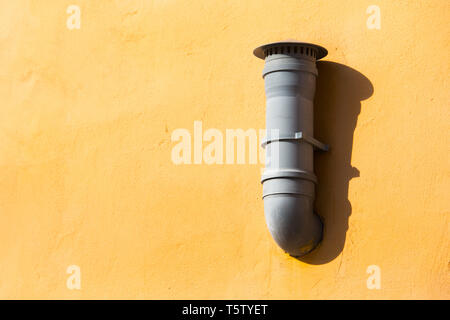 Tuyau de ventilation en plastique orange sur le mur. Tuyau de ventilation de l'air monté sur le mur extérieur. Banque D'Images