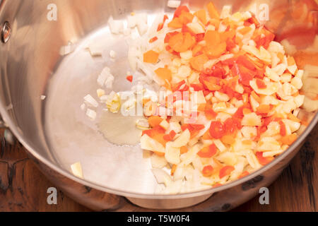 Carottes tranchées et haché, l'ail et l'oignon dans une casserole avec de l'huile prêt à être d'une sauce à spaghetti sautés Banque D'Images