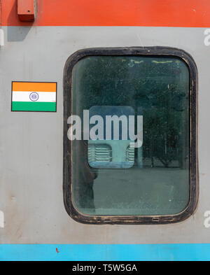 Logo drapeau indien par une fenêtre d'un train de chemin de fer indienne de New Delhi à Kathgodam Uttarakhand en Inde du Nord Banque D'Images