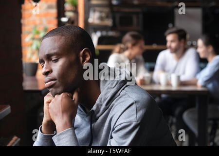 Se sentir seul guy africaine triste assise seule dans cafe Banque D'Images