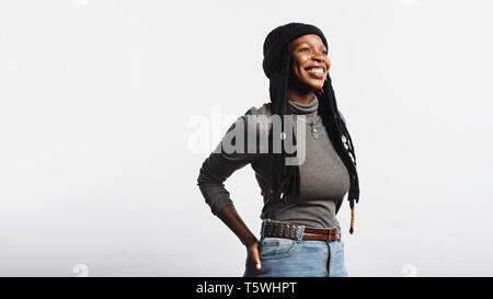 Portrait de femme africaine à joyeuse en jeans et tshirt longues dreadlocks avec cauris. Smiling african woman isolated on white background. Banque D'Images