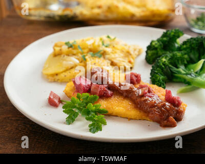 Tranchees vegan avec une sauce tomate Rhubarbe servi avec du gratin de pommes de terre et le brocoli. Banque D'Images