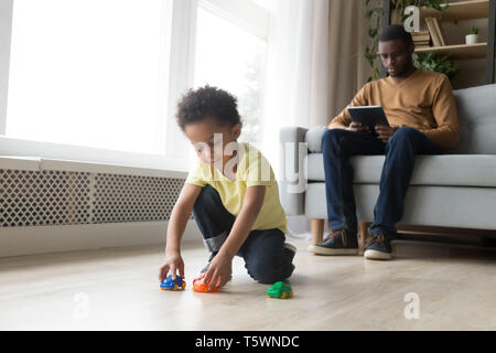 Passer du temps à la maison de la famille kid jouer papa utiliser tablet Banque D'Images