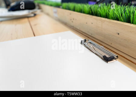 Presse-papiers en plastique blanc vide jeter sur la table en bois. Banque D'Images