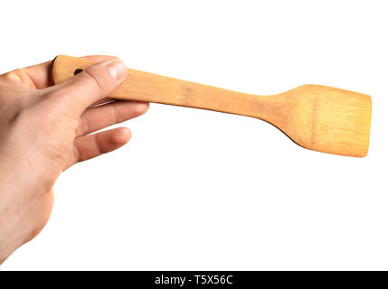 Spatule en bois pour la friture dans la main isolé sur fond blanc. Banque D'Images