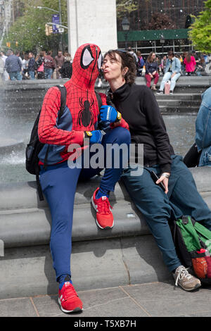Un artiste de rue, artiste habillé en SPIDERMAN pose avec un touriste italien féminin à Washington Square Park, à Manhattan, New York City. Banque D'Images