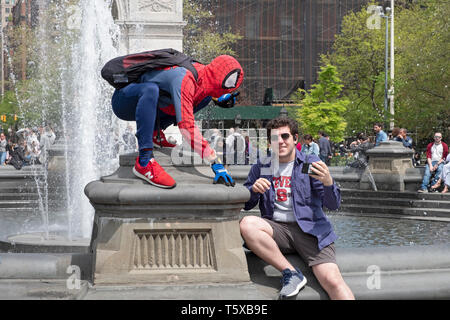 Un jeune homme à Washington Square Park en prenant un artiste de performance avec selfies vêtu d'un costume de Spiderman. Dans la ville de New York. Banque D'Images