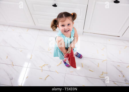 Portrait Of cute girl Throwing Frites sur marbre Banque D'Images