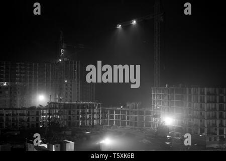 Le travail de nuit sur une surface de bâtiment . Photo en noir et blanc Banque D'Images