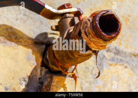 Close up image d'une goutte de l'eau qui goutte d'un robinet rouillé. Image peut être utilisé pour illustrer les économies d'eau. Banque D'Images