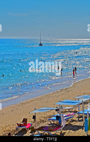 Une vue imprenable sur la plage et mer chatoyante au petit village de pêcheurs d'Olhos D'Agua, dans l'Algarve.la natation de personnes et la location en mer Banque D'Images