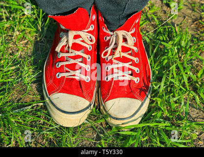 Pieds en rouge sneakers in Green grass Banque D'Images