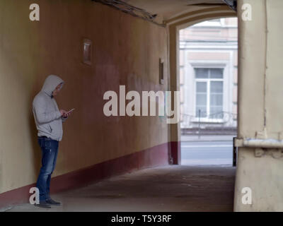 Silhouette d'un homme dans un capot dans la cour arch Banque D'Images
