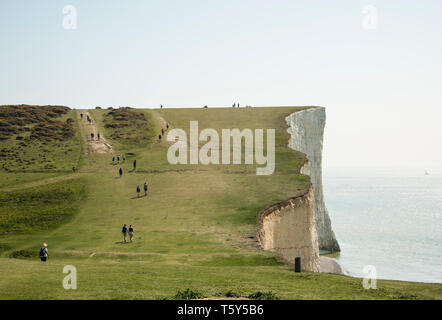 Les gens marcher sur le sentier populaire sur le South downs way entre les sept soeurs des falaises de craie et d'urrugne East Sussex England UK Banque D'Images