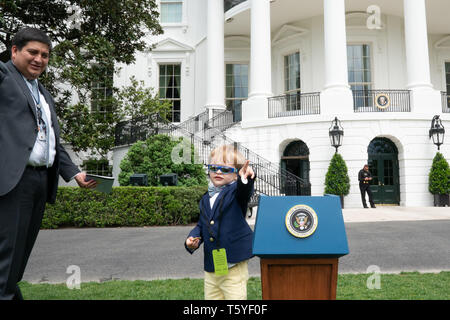 Un enfant se trouve à côté d'un podium miniature sur la pelouse Sud de la Maison Blanche le Jeudi, Avril 25, 2019, tout en participant à l'HouseÕs ÒTake blanc nos filles et fils travaillent jour." Les gens : le Président Donald Trump Banque D'Images