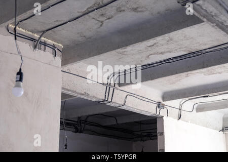 Pose de câbles au plafond. Les fils électriques sur le mur. Remplacement du câblage. La connexion de lumière en appartement ou bureau. L'ampoule électrique, installation professionnelle out Banque D'Images