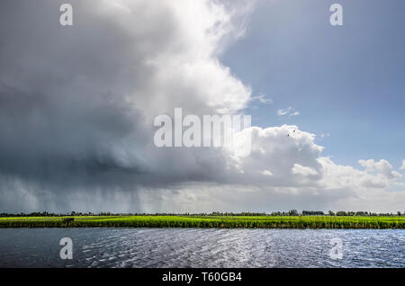 Douche de pluie tomber ses charges au cours de l'Alblasserwaard polder aux Pays-Bas suivie d'une éclaircie Banque D'Images