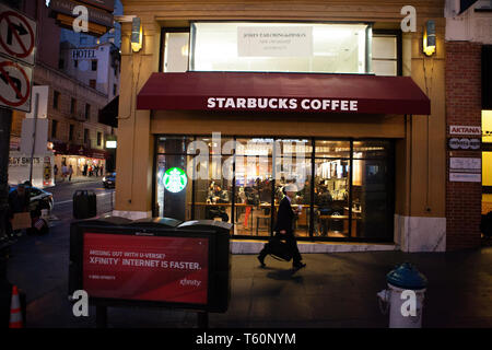 Homme marchant par un café Starbucks au coin d'une rue de San Francisco. Banque D'Images