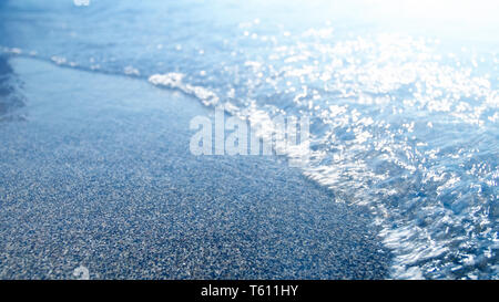 Photo gros plan de bleu de la mer des vagues roulant sur une plage de sable. Résumé des problèmes de mise au point de droit Banque D'Images