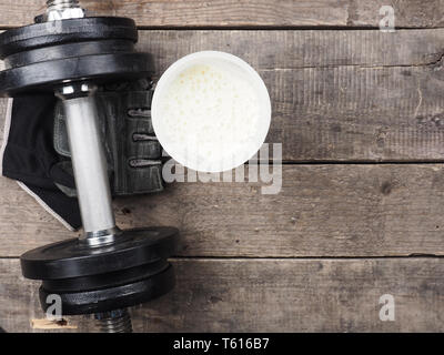 Avec haltère protein shake sur un plancher en bois rustique, vue d'en haut Banque D'Images