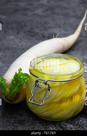 Daikon mariné dans le bocal en verre sur la table Banque D'Images