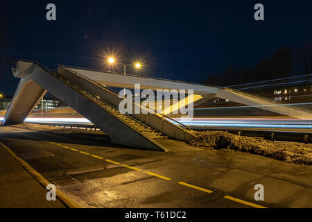 La route de nuit avec un pont piétonnier Banque D'Images