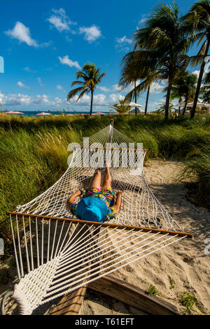 Relaxing in hammock on Grace Bay Beach, Providenciales, Turks et Caicos, Caraïbes. (MR) Banque D'Images