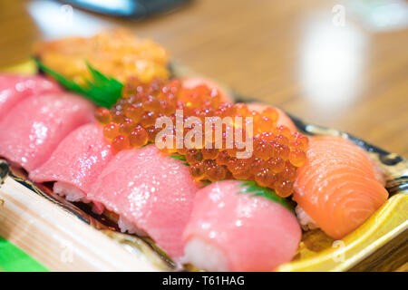 Saumon sushi sushi et d'autres sont disposés dans l'usine de mousse sur la table prêt à manger au marché aux poissons Kuromon, Osaka, Japon Banque D'Images