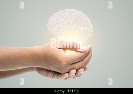 Man holding cerveau illustration contre mur gris. Concept avec la protection et les soins de santé mentale. Banque D'Images