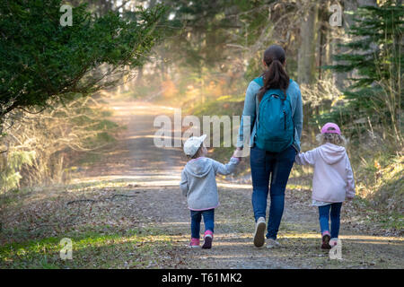 Randonnées dans les bois. Mère avec ses filles marcher sur un chemin dans une forêt ensoleillée. La Suède Banque D'Images