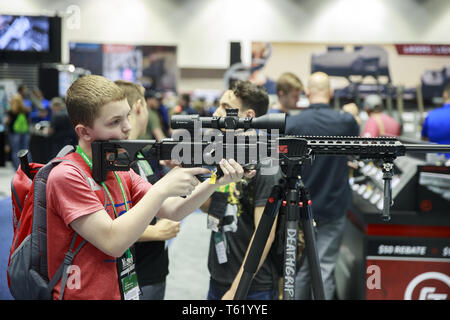 Indianapolis, Indiana, au Royaume-Uni. Apr 27, 2019. Un garçon regarde à travers la portée d'un fusil au cours de la troisième journée de la National Rifle Association convention. Crédit : Jeremy Hogan/SOPA Images/ZUMA/Alamy Fil Live News Banque D'Images