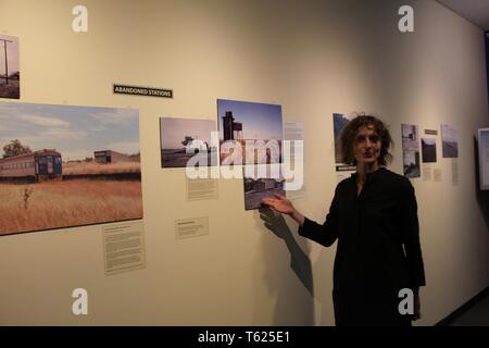 Adélaïde, Australie. Apr 27, 2019. Emily Collins, le commissaire de l'exposition "Les fantômes du passé, des stations photos présente aux visiteurs à le National Railway Museum, à Adélaïde, Australie, le 27 avril 2019. Le musée accueille une exposition "Les fantômes du passé" Stations avec plus de 20 100 photos et vidéos qui racontent l'histoire de hauts et les bas des services ferroviaires et de se souvenir de l'ex-gares éparpillés le long avec le réseau ferroviaire en l'état. L'exposition a débuté le samedi et se poursuit jusqu'au 31 mai. Credit : Bai Xu/Xinhua/Alamy Live News Banque D'Images