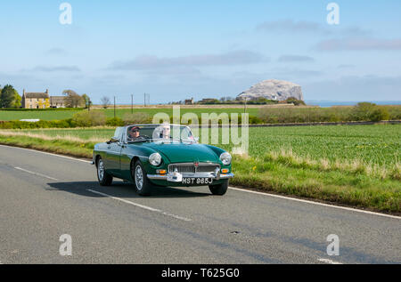 East Lothian, UK. 28 avril 2019. Voiture Classique Tour : North Berwick Rotary Club organise son 3ème rallye avec 65 voitures inscrites. La voiture parcours est de East Lothian et retourner par le Scottish Borders, la collecte de fonds pour les organismes de bienfaisance locaux. Un millésime 1970 MG voiture sport décapotable avec Bass Rock dans le Firth of Forth en arrière-plan Banque D'Images