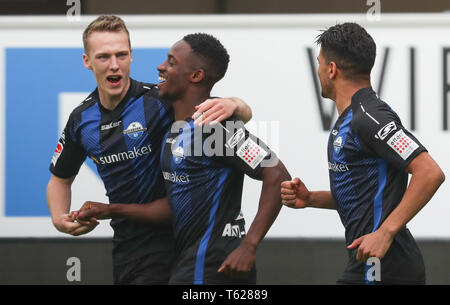 Paderborn, Allemagne. Apr 28, 2019. Soccer : 2ème Bundesliga, SC Paderborn 07 - 1er FC Heidenheim, 31e journée à l'Aréna de Benteler. Paderborn's scorer Christopher Antwi-Adjej (M) célèbre son but avec 1-0 Sebastian Schonlau (l) et Mohamed Dräger (r). Credit : Friso Gentsch/DPA - NOTE IMPORTANTE : en conformité avec les exigences de la DFL Deutsche Fußball Liga ou la DFB Deutscher Fußball-Bund, il est interdit d'utiliser ou avoir utilisé des photographies prises dans le stade et/ou la correspondance dans la séquence sous forme d'images et/ou vidéo-comme des séquences de photos./dpa/Alamy Live News Banque D'Images