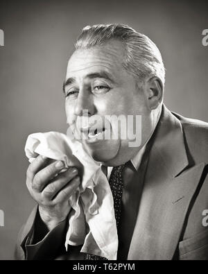 1940 Souffrance senior man sur le point d'éternuer dans un mouchoir - HAR3889001 HARS, STUDIO SHOT MALADIE SANTÉ MANAGER PERSONNES MÂLES MAL SUR LES CADRES D'ÂGE MOYEN DES EXPRESSIONS B&W middle-aged MAN costume et cravate DE SOINS DE BIEN-ÊTRE LA PRÉVENTION DES SOUFFRANCES OLDSTERS TÊTE ET ÉPAULES ANTIQUE DE LA FIÈVRE EN DÉTRESSE À L'ALLERGIE LE DIAGNOSTIC DE GUÉRISON avec le mouchoir faible détresse explosive dans l'ANGLE DES SOINS DE SANTÉ À L'ÉCHELLE DE TRAITEMENT DE VALEUR ANCIENS PATRONS DE REVERS CONCEPTUEL IRRITATION ALLERGIQUE PROPAGATION DE VIRUS COMPULSIVE DES GESTIONNAIRES EN NOIR ET BLANC DE L'ORIGINE ETHNIQUE CAUCASIENNE HAR MALADIE001 old fashioned Banque D'Images