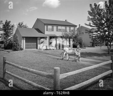 1970 DEUX JEUNES FILLES SOEURS LA BICYCLETTE DANS LA COUR DE LA MAISON DE BANLIEUE - b25683 HAR001 HARS DE BÂTIMENTS RÉSIDENTIELS FRÈRES SOEURS BICYCLETTES B&W VÉLOS LOISIRS EXTÉRIEURS LE BONHEUR DANS DES MAISONS élégantes résidences FRÈRE MINEURS TOGETHERNESS NOIR ET BLANC DE L'ORIGINE ETHNIQUE CAUCASIENNE HAR001 old fashioned Banque D'Images