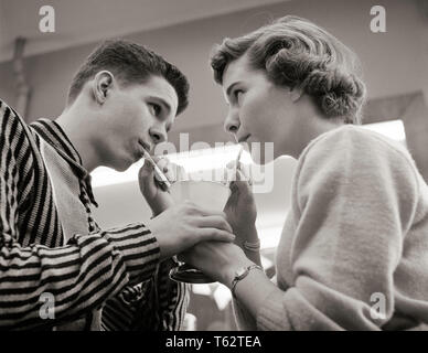 1950 TEENAGE COUPLE SHARING ICE CREAM SODA AU COMPTOIR REPAS DEUX PAILLES UNE BOISSON - f8343 HAR001 HARS D'ÉQUIPE DES JEUNES ADULTES FEMELLES VIE JOIE TACTILE COPIE Espace demi-longueur d'AMITIÉ LES PERSONNES QUI S'OCCUPENT LES HOMMES TEENAGE GIRL BOY PARTAGER PAILLES B&W DATING ATTRACTION ANGLE FAIBLE CONNEXION RELATIONS SODA de cour élégante fontaine jeunes adolescents ICE CREAM SHOP MALT ICE CREAM SODA POSSIBILITÉ AMOURS JUVÉNILES SOLIDARITÉ COOPÉRATION ACTIVITÉ SOCIALE DES JEUNES ADULTES JEUNES ADULTES HOMME FEMME NOIR ET BLANC DE L'ORIGINE ETHNIQUE CAUCASIENNE COURTING HAR001 Chemise rayée à l'ANCIENNE Banque D'Images