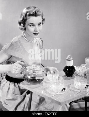 1950 24,99 $ FEMME MÉNAGÈRE AU SERVICE VERSANT THÉ CAFÉ ASSIS À TABLE - f913 CLE003 HARS, maîtresse de maison CLOSE STYLES BOISSONS MÉNAGÈRES FIERTÉ HÔTESSE ÉLÉGANT HÔTE SOUCOUPES FASHIONS MID-ADULT MID-ADULT WOMAN NOIR ET BLANC à l'ANCIENNE Origine ethnique Caucasienne Banque D'Images