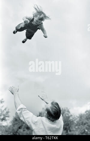 Années 1950 Années 1960 FUN OU DANGEREUSEMENT STUPIDE PÈRE FILLE ENFANT EN JETANT EN L'AIR HAUT ET EN ATTENDANT DE REPRENDRE SON DESCENDANT - j1789 FIL001 HARS JETANT JOIE SÉCURITÉ VIE RURALE VIE FEMELLES ACCUEIL COPIE CAPTURES D'ESPACE DE REMISE EN FORME PHYSIQUE pleine longueur filles les personnes qui s'occupent les hommes de confiance RISQUE DE DANGER B&W PÈRES BONHEUR LIBERTÉ DE LA TÊTE ET DES ÉPAULES ET FORCE DE LA PROTECTION D'ANGLE DE HAUTE EXCITATION PAPAS LOW ANGLE RIDICULE DANS L'AUTORITÉ DE LANCER CONCEPTUEL OU LA CROISSANCE DES JEUNES ADULTES MI-homme mi-adulte bébé fille ENSEMBLE DÉTENTE NOIR ET BLANC à l'ANCIENNE Origine ethnique Caucasienne Banque D'Images