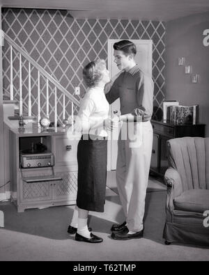 1950 ENAMOURÉ TEENAGE COUPLE WEARING BOBBY CHAUSSETTES ET CHAUSSURES LOAFER PENNY danser dans la vie en banlieue PRIX RECORD PLAYER - j8416 HAR001 HARS SANTÉ VIE SAINE ACCUEIL ESPACE COPIE PLEINE LONGUEUR D'AMITIÉ LES PERSONNES QUI S'OCCUPENT DE DIVERTISSEMENT ADOLESCENT ADOLESCENTE CONFIANCE B&W DATING RÊVES BONHEUR SALON ATTRACTION PANTALON TROTTEURS FRÉQUENTATIONS ADOLESCENTES SUPPORT ÉLÉGANT BOBBY SOX POSSIBILITÉ SOCIALE SOLIDARITÉ COOPÉRATION ACTIVITÉ NOIR ET BLANC CHAUSSETTES BOBBY CAUCASIAN ETHNICITÉ COURTING HAR001 old fashioned Banque D'Images