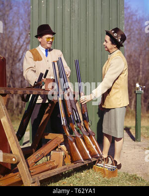 Des années 1960, mari et femme de l'ÉQUIPE DE TIR COMPÉTITIF COUPLE parler ensemble s'apprêtait à tourner SKEET MATCH - ks juegos HAR001 style relaxant HARS LES FEMMES RURALES MARIÉS MARI CONJOINT Préparation de la copie intégrale de l'Espace Femmes Personnes POUSSE LES HOMMES À LA CONFIANCE SPORTIVE PARTENAIRE D'ÂGE MOYEN TOUR HOMME D'ÂGE MOYEN DE L'ACTIVITÉ COMPÉTENCES AMUSEMENT BONHEUR PASSE-TEMPS FORCE L'INTÉRÊT ET L'ENGOUEMENT DES LOISIRS PASSE-TEMPS PASSE-TEMPS PLAISIR DE SAVOIR CONCEPTUEL GAMME CONCURRENTIELLE DE SKEET ÉLÉGANT MI-ARMES À FEU ARMES À FEU MI-ADULTES FEMME ADULTES ENSEMBLE RELAXATION AMATEUR FEMMES L'ORIGINE ETHNIQUE CAUCASIENNE JOUISSANCE HAR001 Banque D'Images