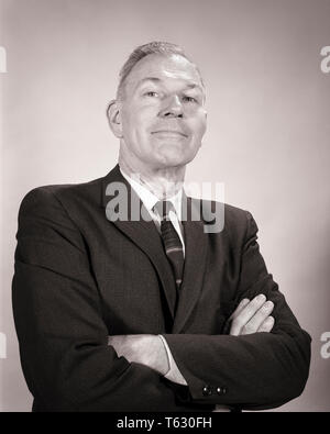 1960 MAN les bras croisés plié avec auto-satisfait de l'expression faciale supérieure BÉAT LOOKING AT CAMERA - s14663 HAR001 HARS, fierté de la politique politicienne SUPÉRIEURE VENDEURS NOIR ET BLANC PORTRAIT ETHNICITÉ HAR001 auto-satisfait à l'ANCIENNE Banque D'Images